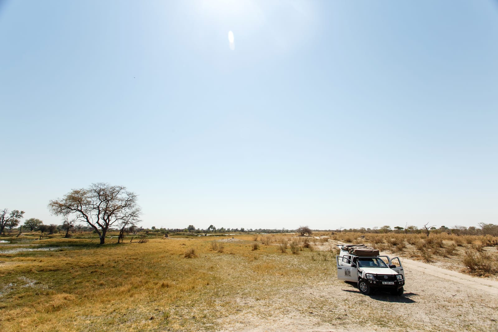 Geländewagen mit Dachaufbau auf einer Sandpiste im Moremi-Wildreservat